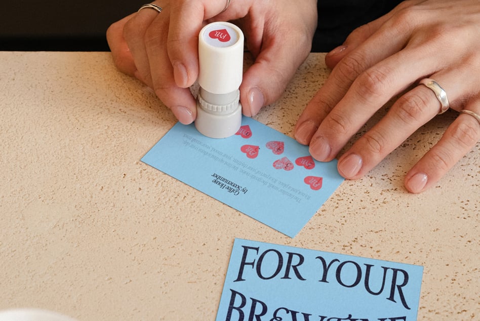 Stamp pressing red impressions on light blue card mockup