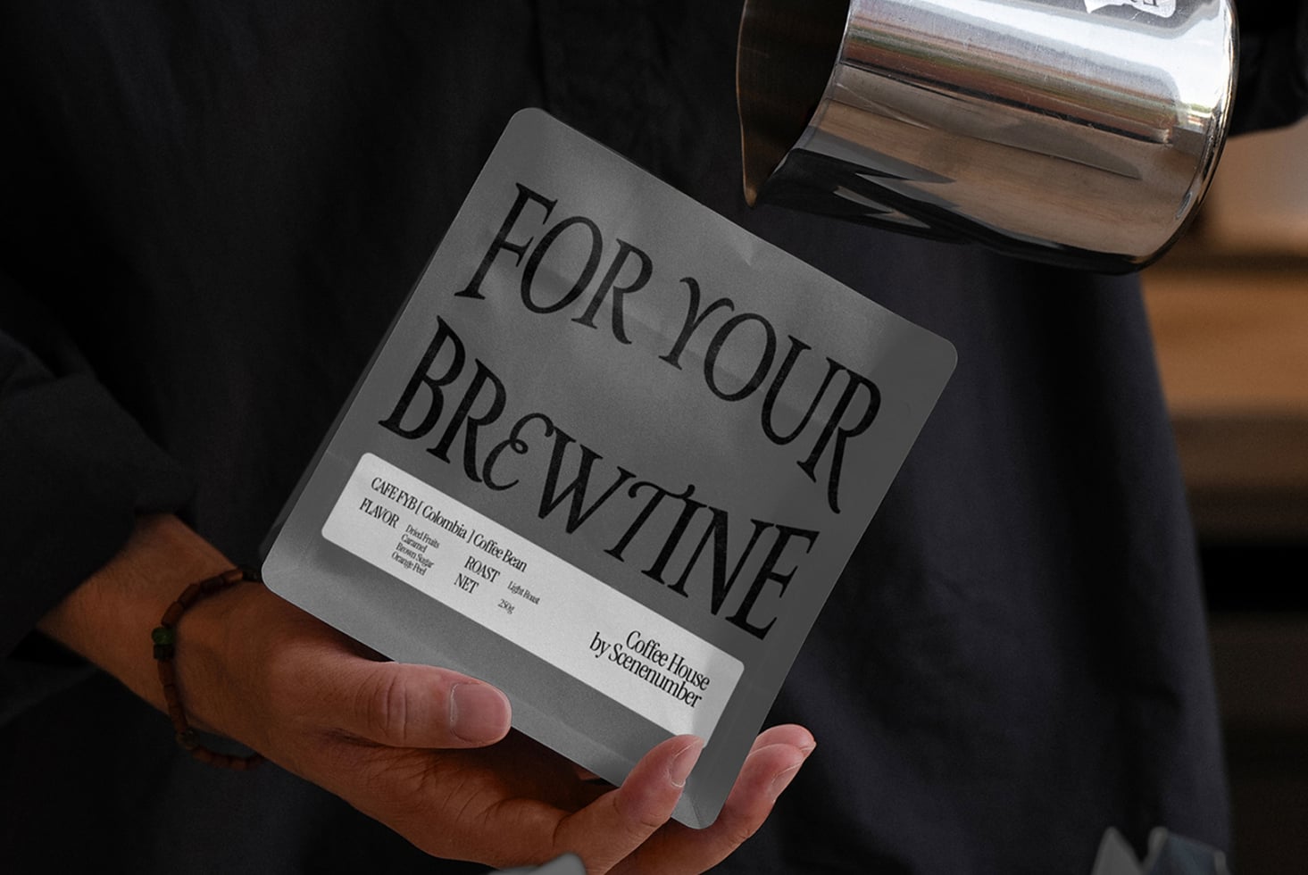 Gray coffee bag mockup held in hand with white label on dark background