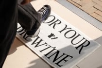 White doormat mockup with bold serif lettering on tile entryway floor