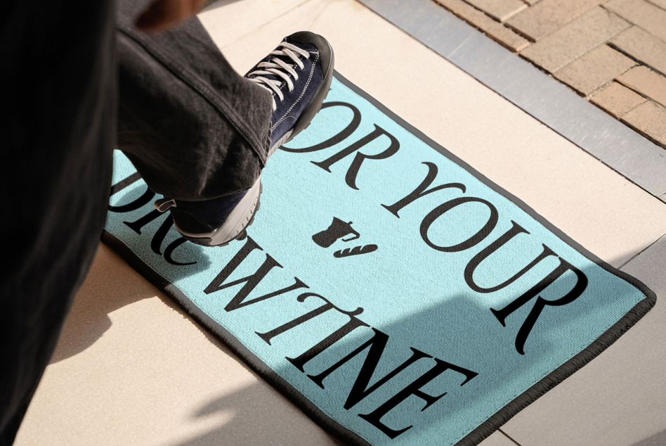 Bright blue doormat mockup with large serif text, foot stepping on entryway