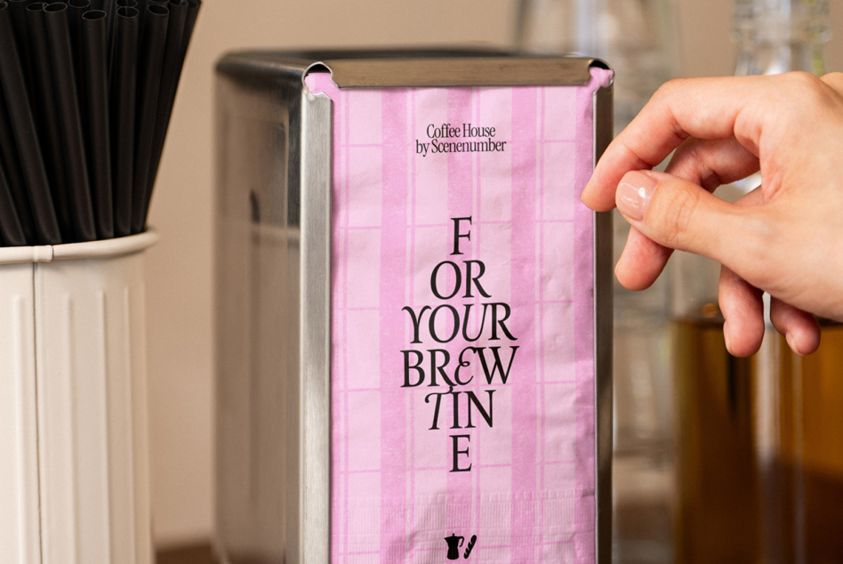 Pink napkin mockup held in hand with coffee house branding design