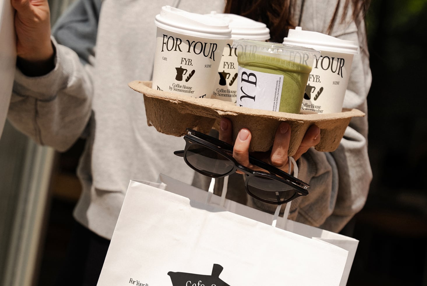 Cream colored cups in cardboard carrier with sunglasses, white shopping bag mockup