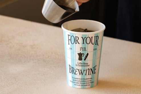 Teal striped coffee cup with For Your FYB Brewtine branding, filled with dark coffee