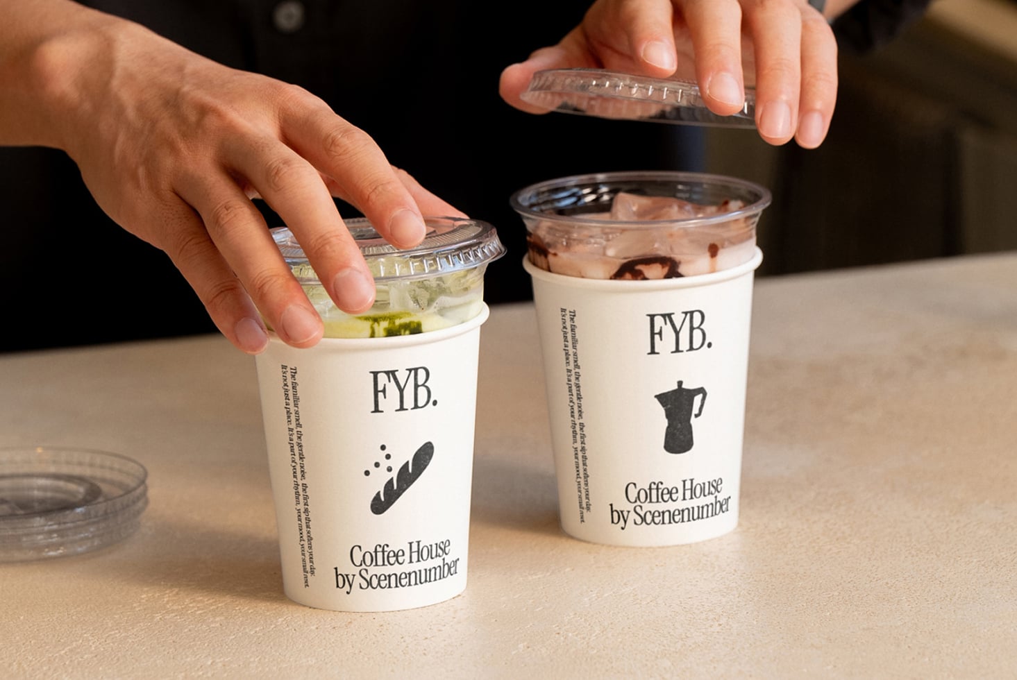 Two hands opening clear cup lids on beverages with different drink colors inside
