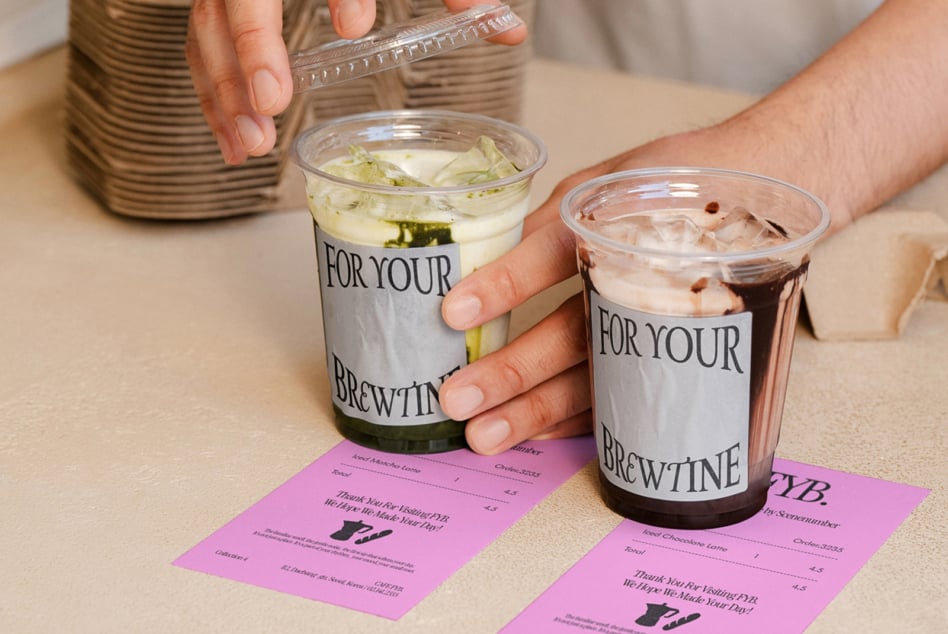 Two coffee cups with For Your Brewtine labels beside matching pink receipt mockups