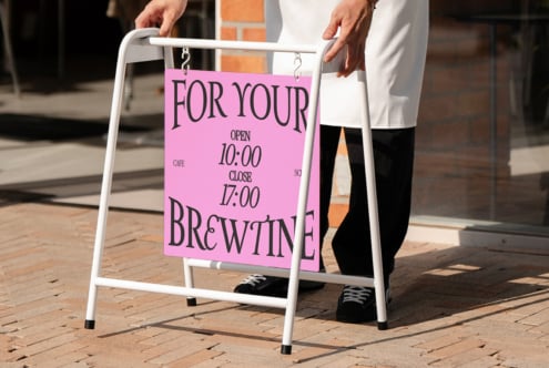 White sandwich board with magenta cafe sign mockup held by person outside