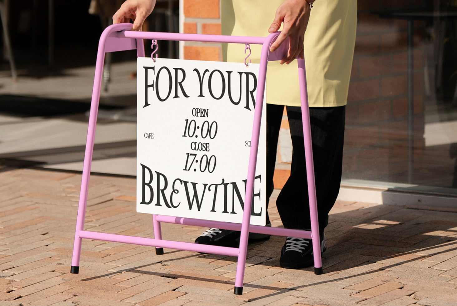 Pink sandwich board sign with cafe hours mockup held by person outdoors