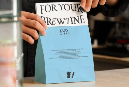 Blue folded coffee bag mockup with text layout, person holding displayed sample