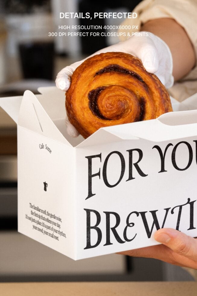 Hands holding white pastry box with golden spiral pastry visible, coffee branding
