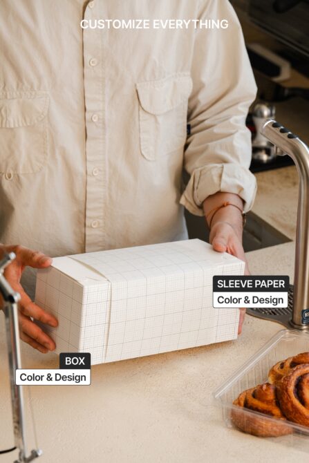 Bakery box mockup in hands showing customizable sleeve, box design, grid pattern