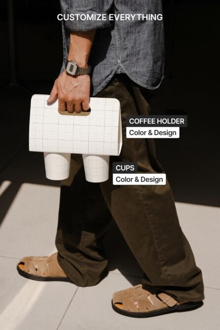 Person carrying grid-pattern coffee holder with two white cups, styled outfit shot