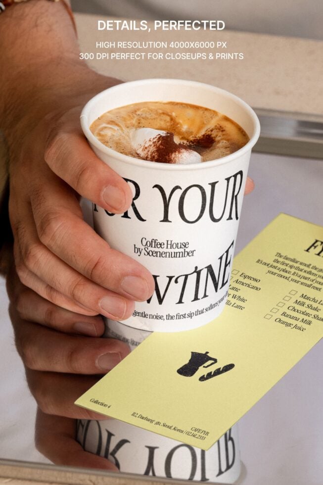 Close up of latte with latte art held in hand with yellow takeout menu