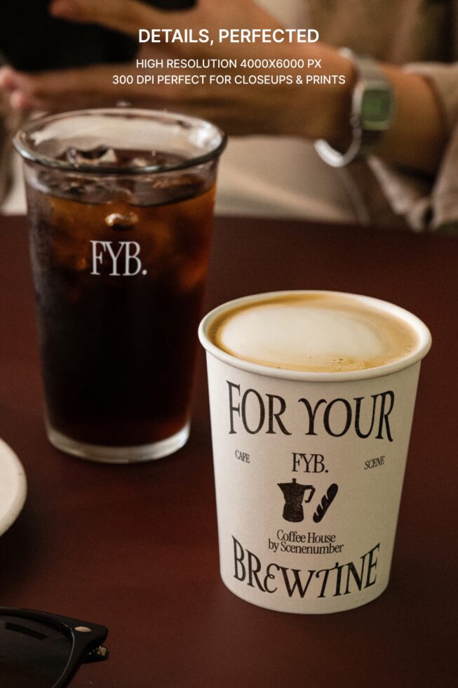 White coffee cup with latte, iced cola drink on dark brown café table setup