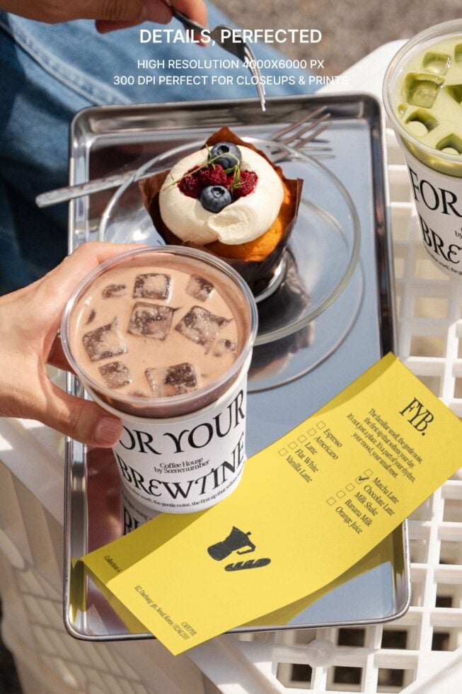 Flat lay of iced coffee, chocolate drink with ice, fruit topped pastry, yellow order slip