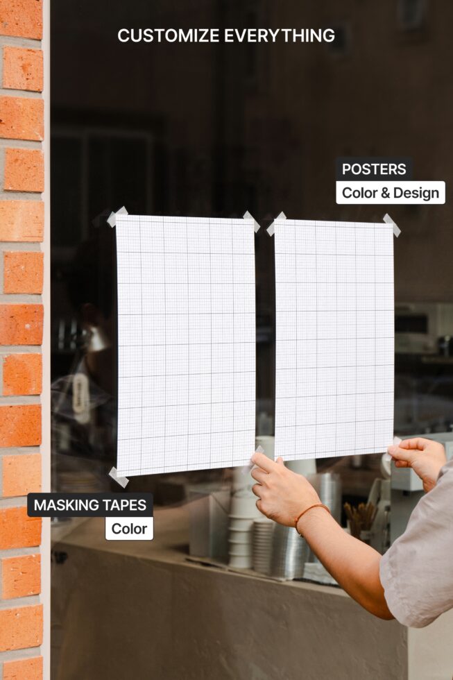 Two blank posters held up against brick building with masking tape corners