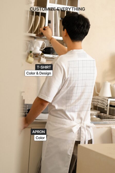 Person from behind wearing white tee with grid pattern mockup on kitchen cabinet