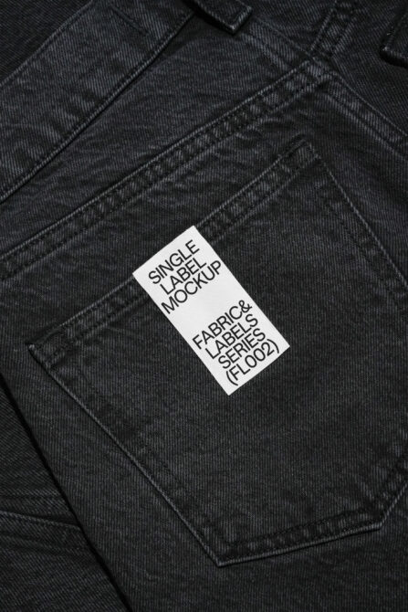 White fabric label on dark denim with black text reading Single Label Mockup