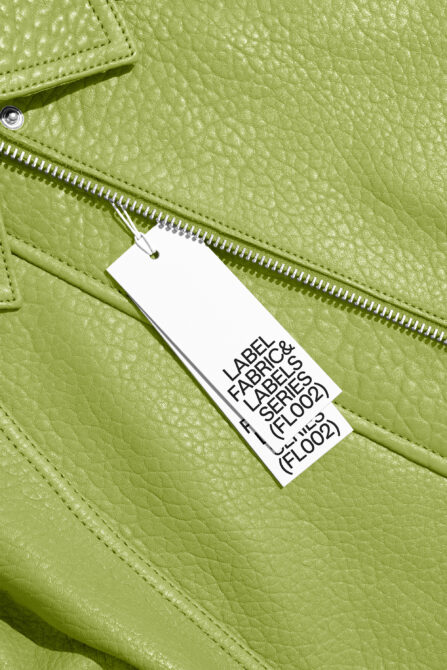 Close-up of lime green leather bag with white hang tag on silver zipper