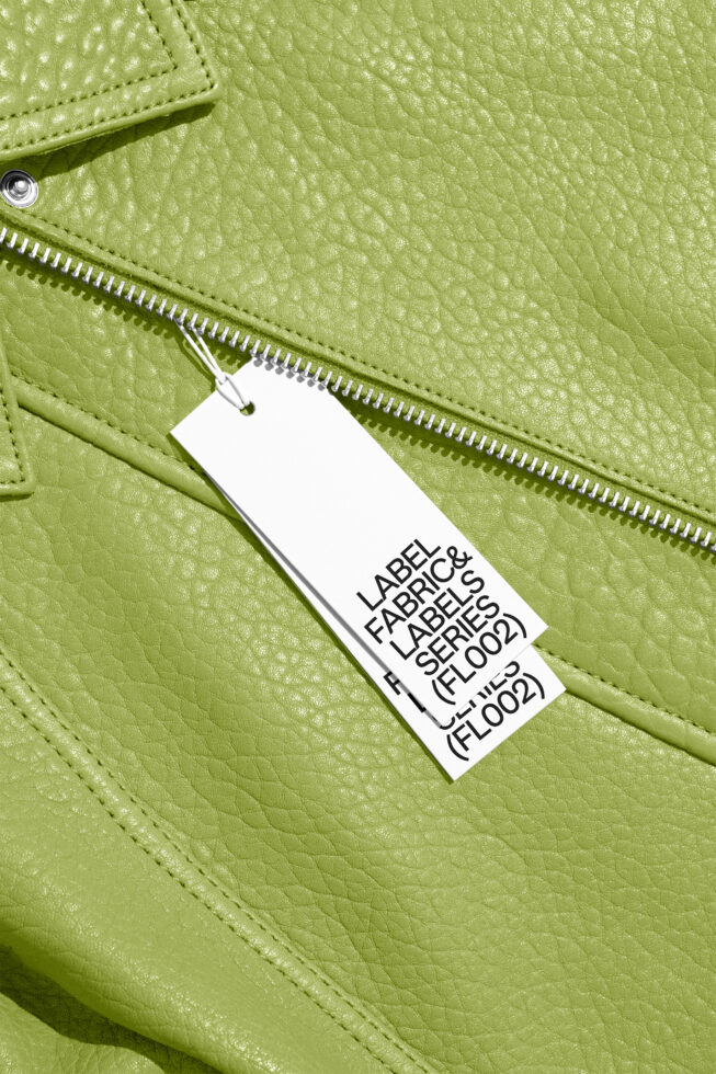 Close-up of lime green leather bag with white hang tag on silver zipper