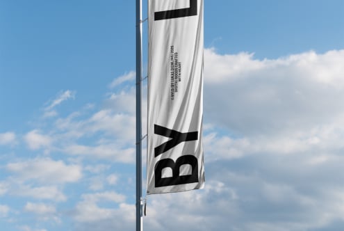 White banner flag with black logo symbol, digital goods credit text on red sky