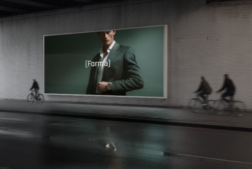 Street billboard displaying suited man in green blazer with (Forma) overlay text