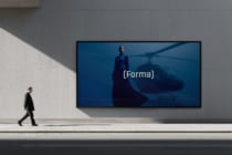 Walking figure passing widescreen display featuring cinematic helicopter scene