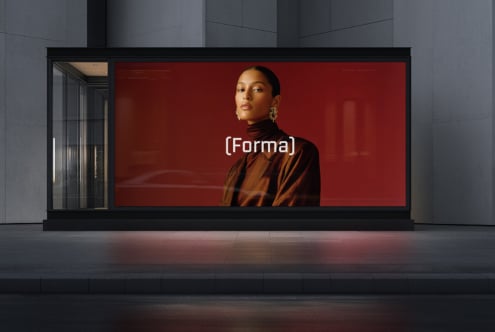 Store window featuring woman in bronze jacket against crimson background display