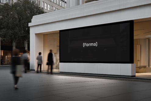 Modern storefront with large black digital screen displaying text in urban setting