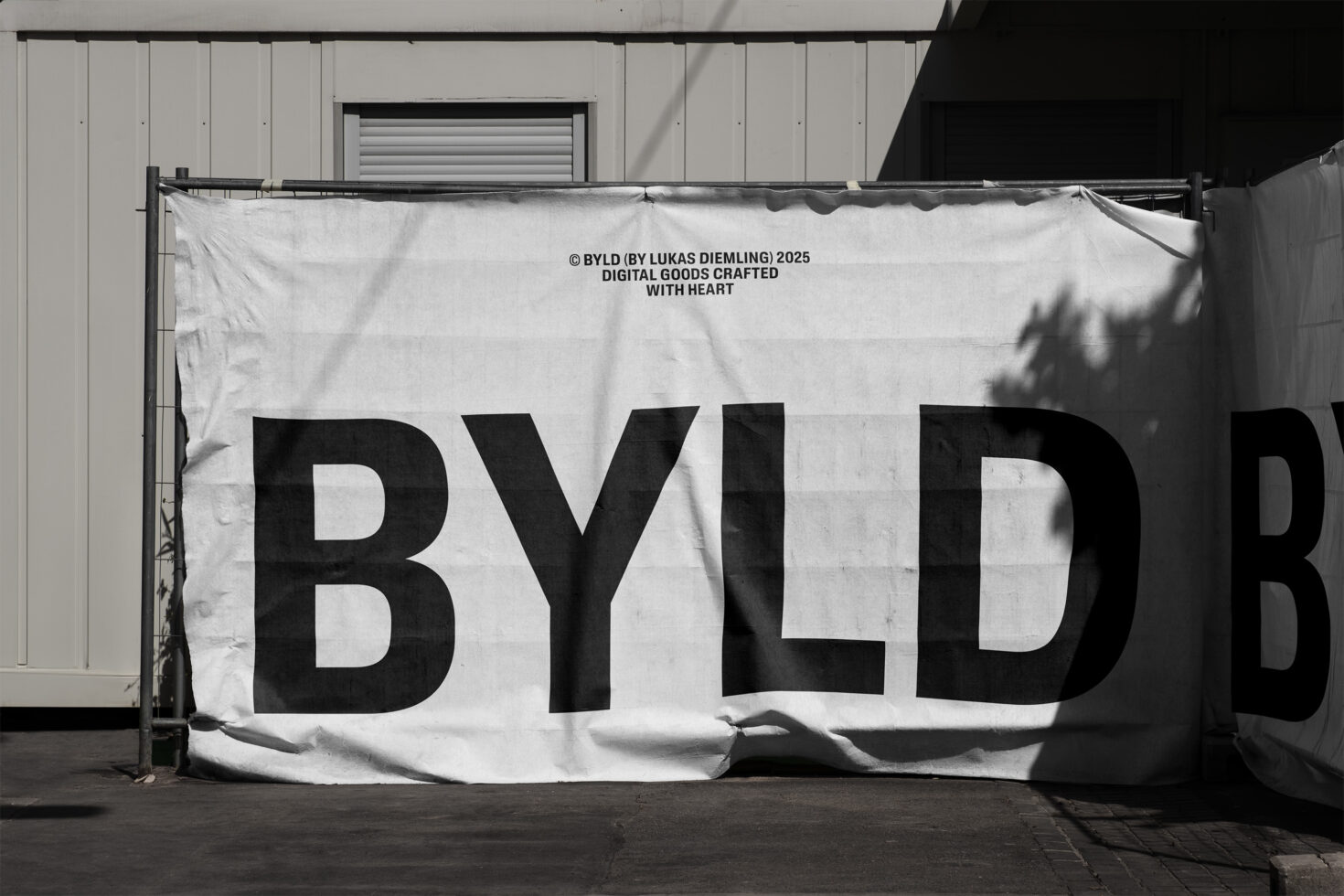 Large white banner with bold black BYLD text hanging on industrial building