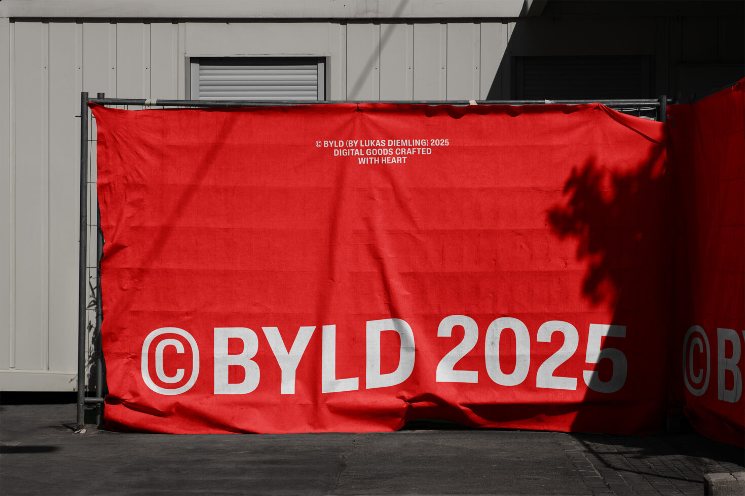 Bright red fabric banner hung on industrial wall with white printed text