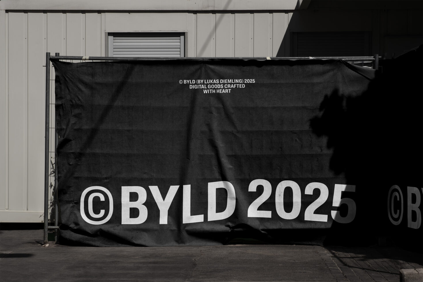 Black fabric banner displaying copyright BYLD 2025 in white letters outdoors