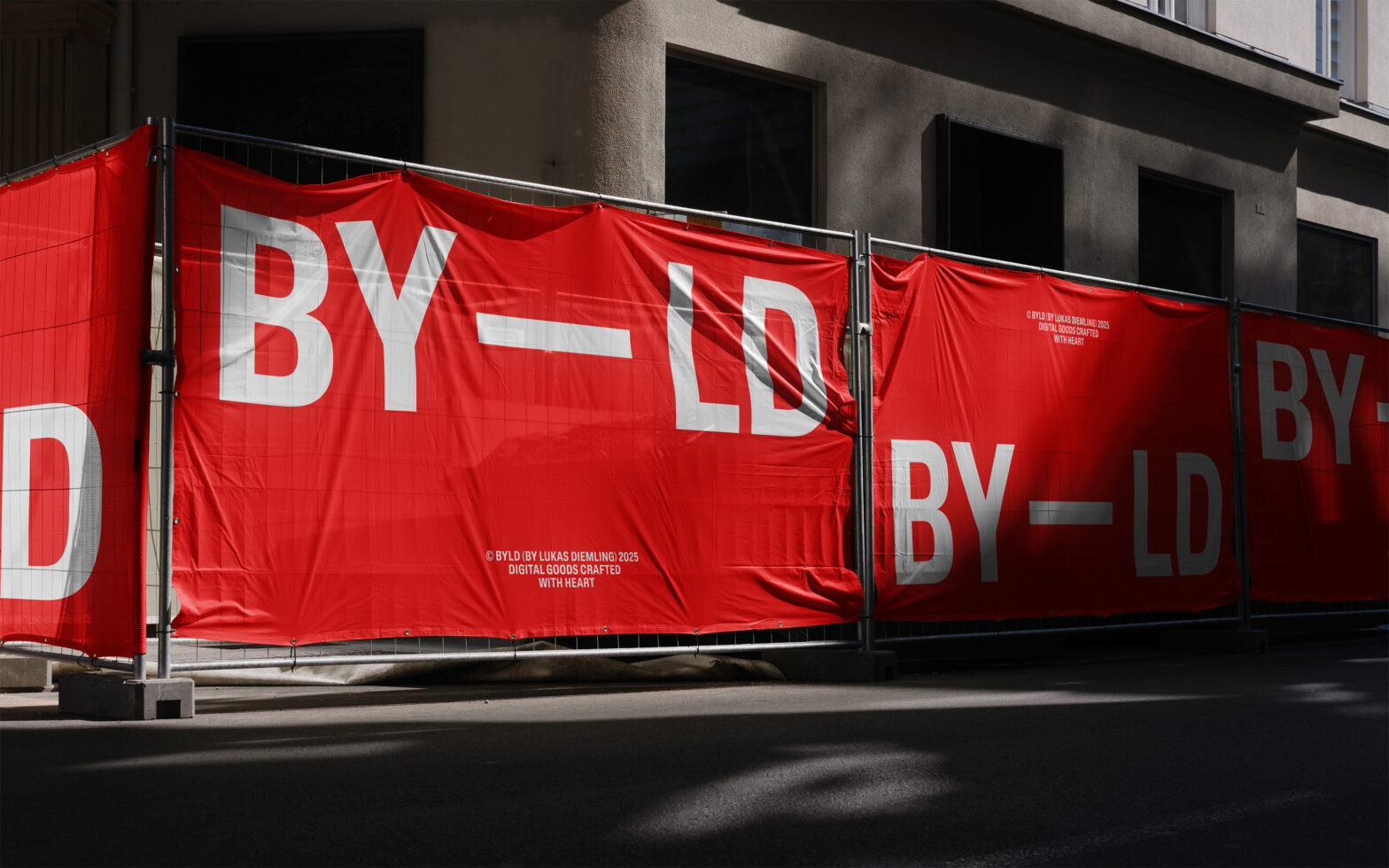 Red construction site banner with large white BYLD text on fabric mesh