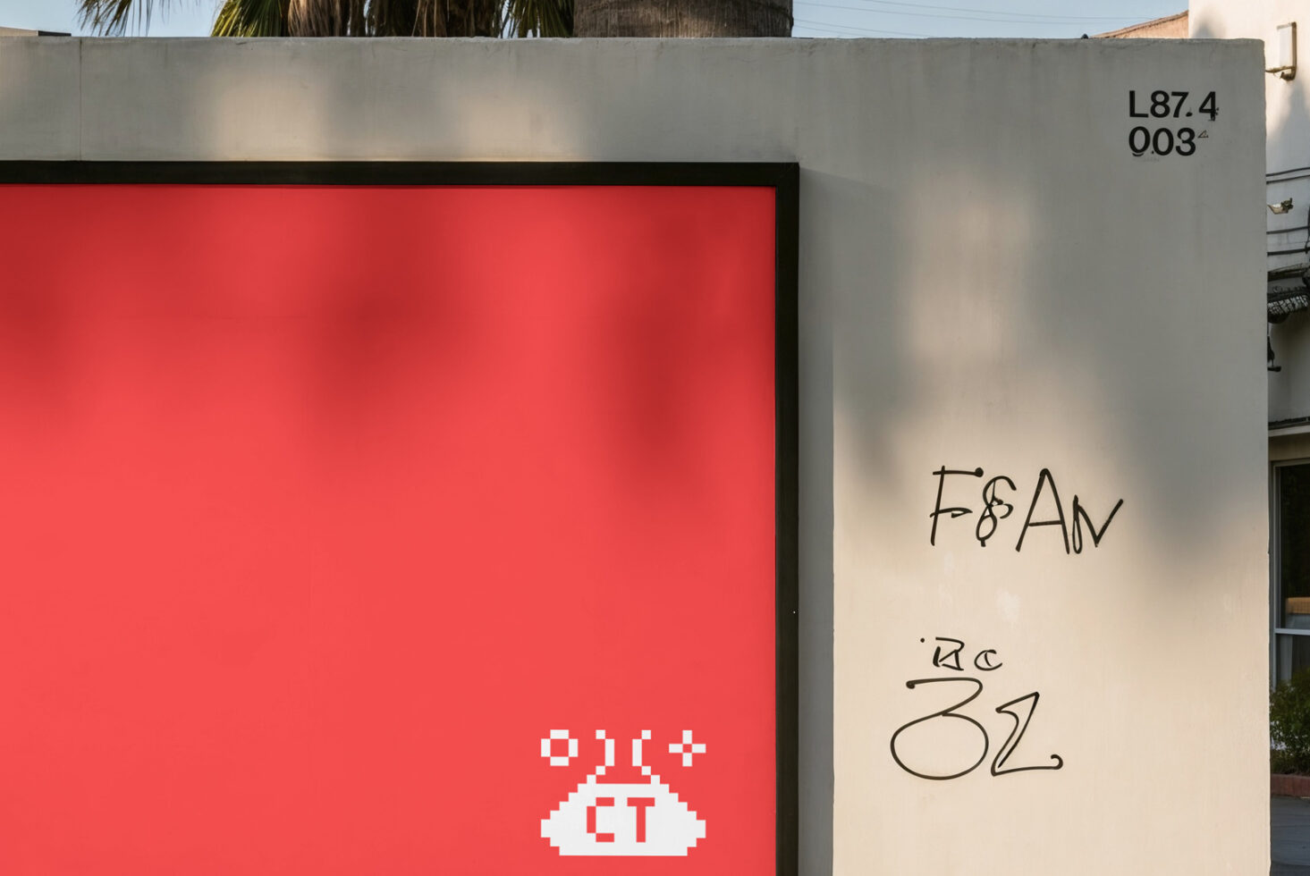 Street-level billboard with solid red panel, pixel ET icon, white wall beside