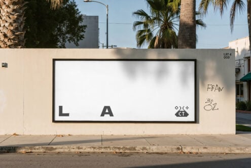 Storefront billboard mockup with blank white screen, LA text, palm trees background