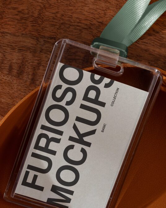 Clear ID badge mockup with green ribbon on wood texture surface