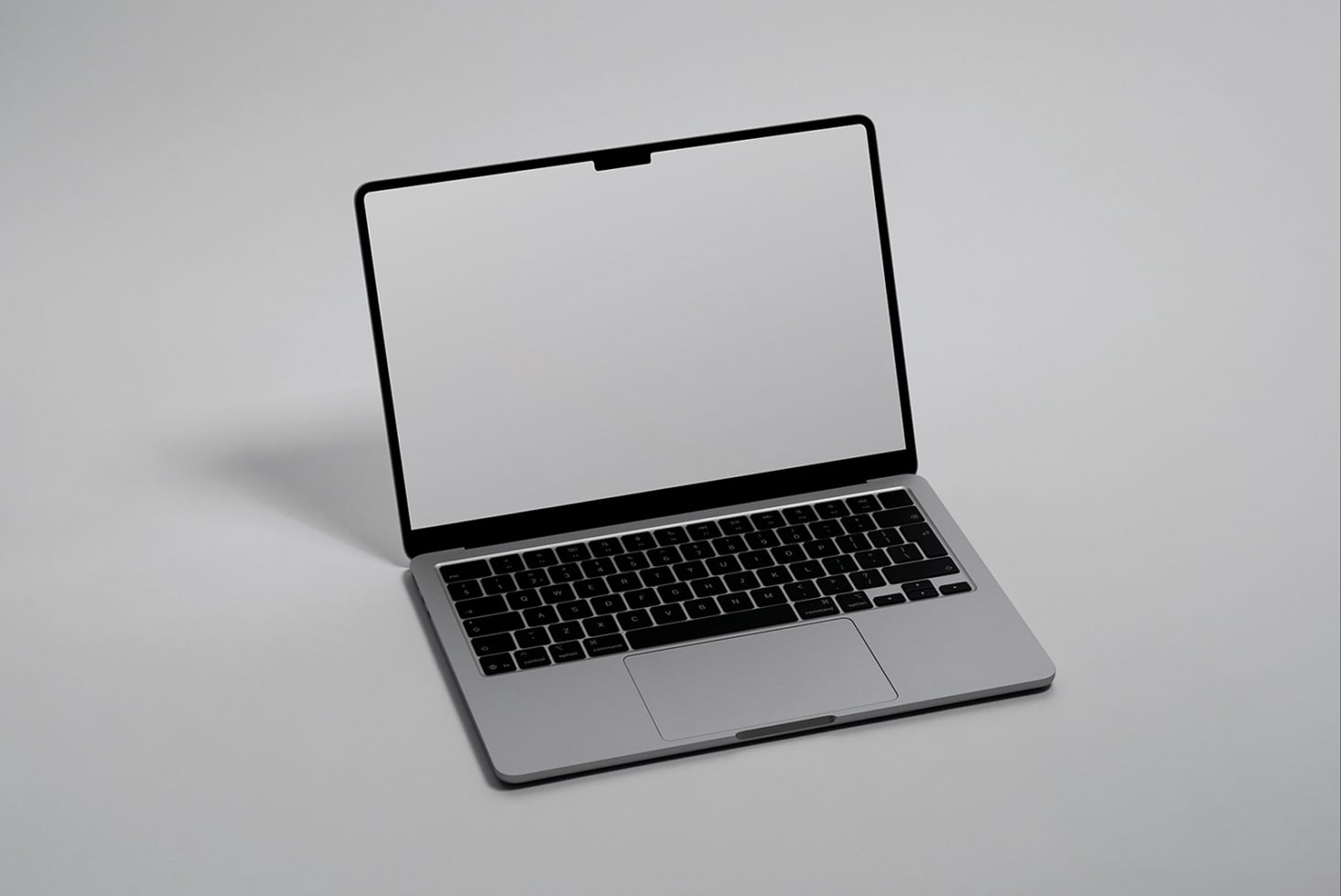 Silver macbook open with blank white screen on gray background