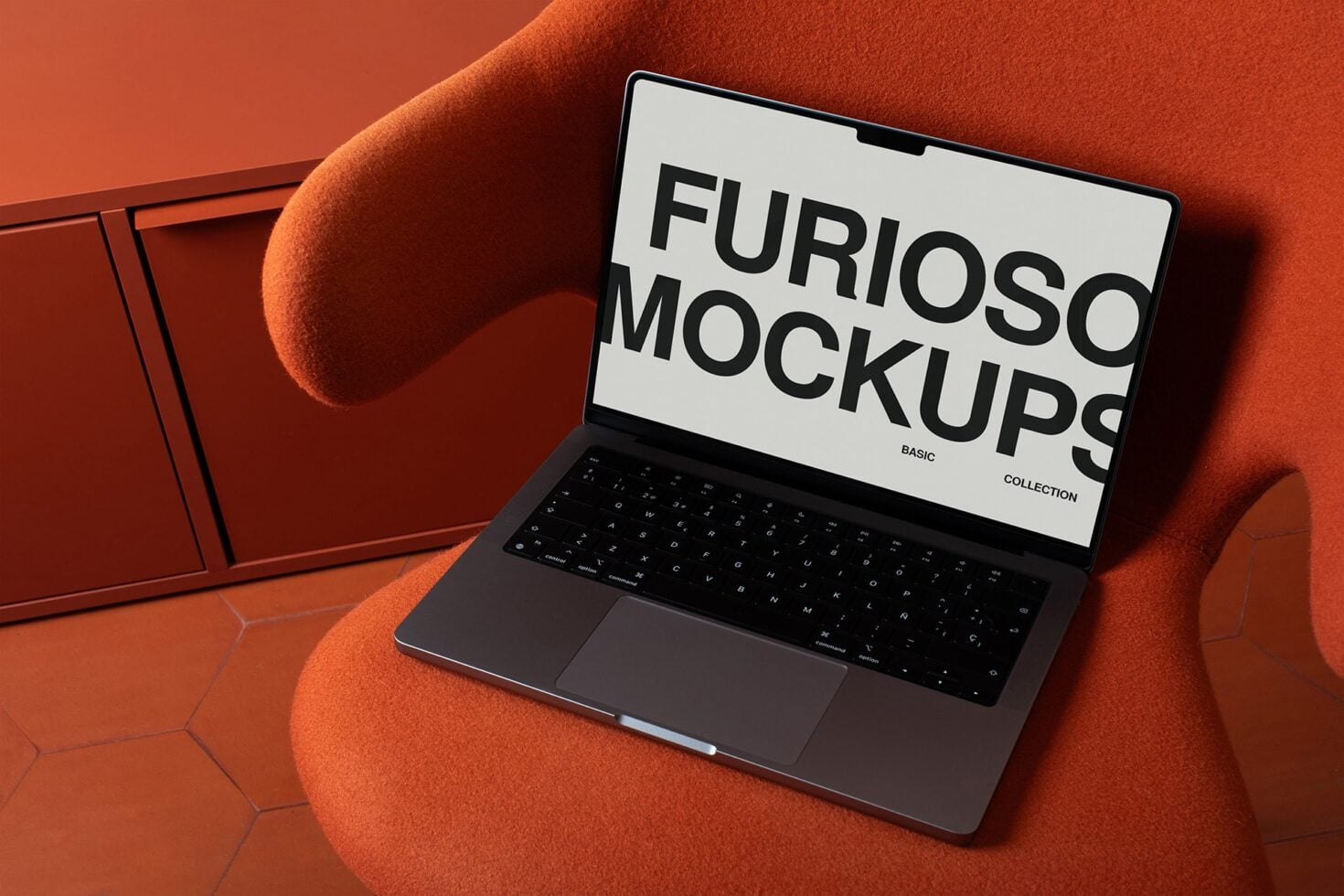 Laptop displaying white screen with large black sans serif type on orange fabric