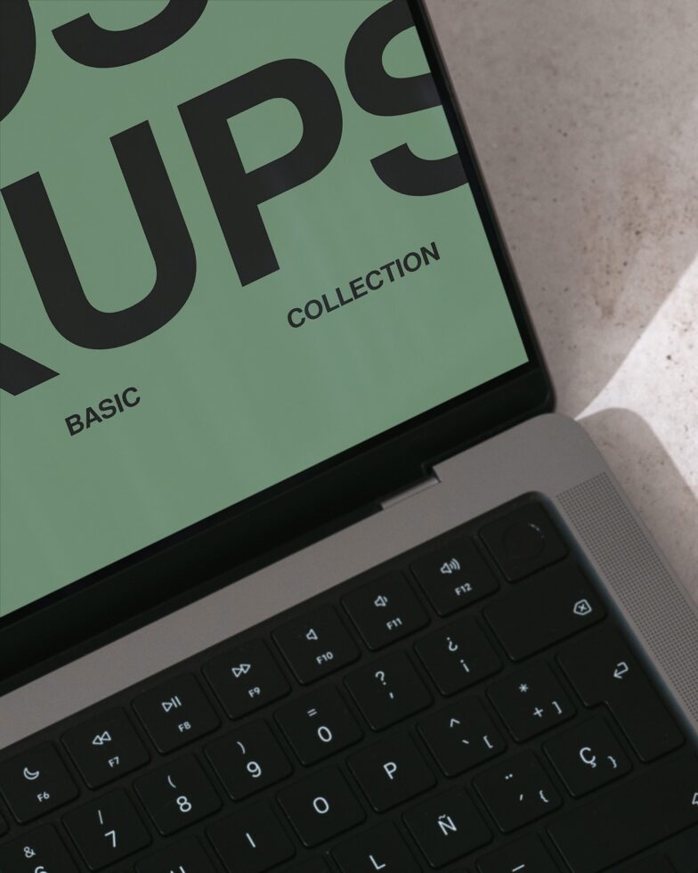 Laptop showing sage green screen with large black Furioso letters, Basic Collection label visible