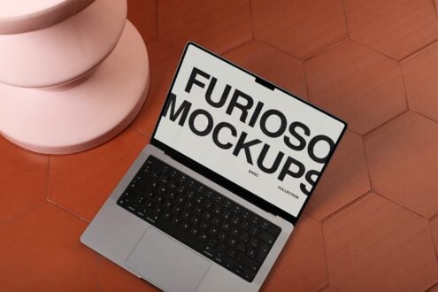Silver laptop showing white mockup design on textured hexagonal surface