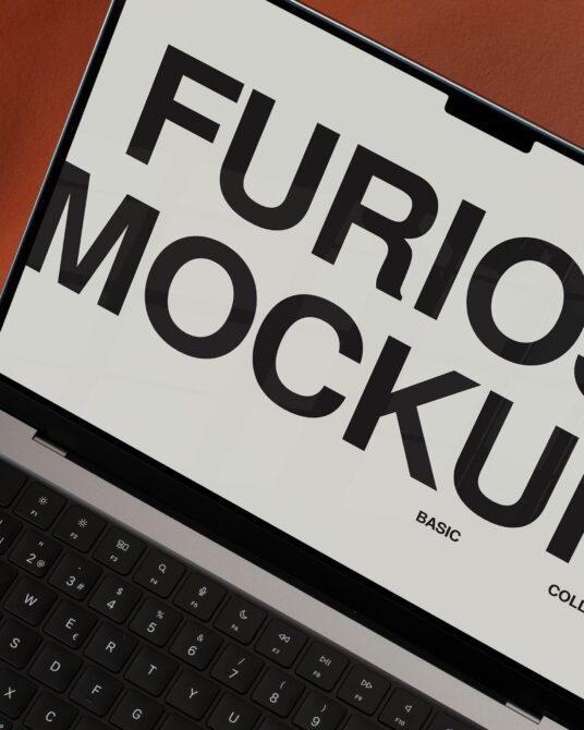 Laptop screen displaying orange mockup design next to black keyboard