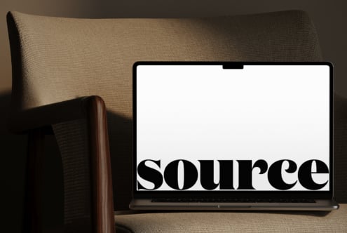 MacBook screen showing serif font design in minimal home setting