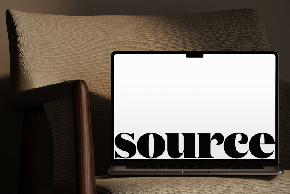 MacBook screen showing serif font design in minimal home setting