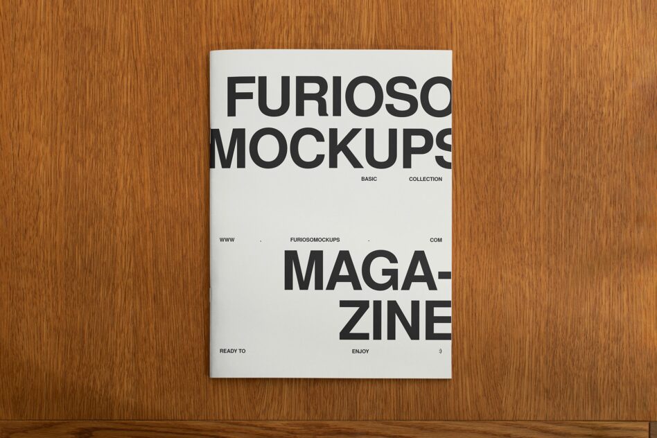 White magazine spread layout on wood with bold black text typography design