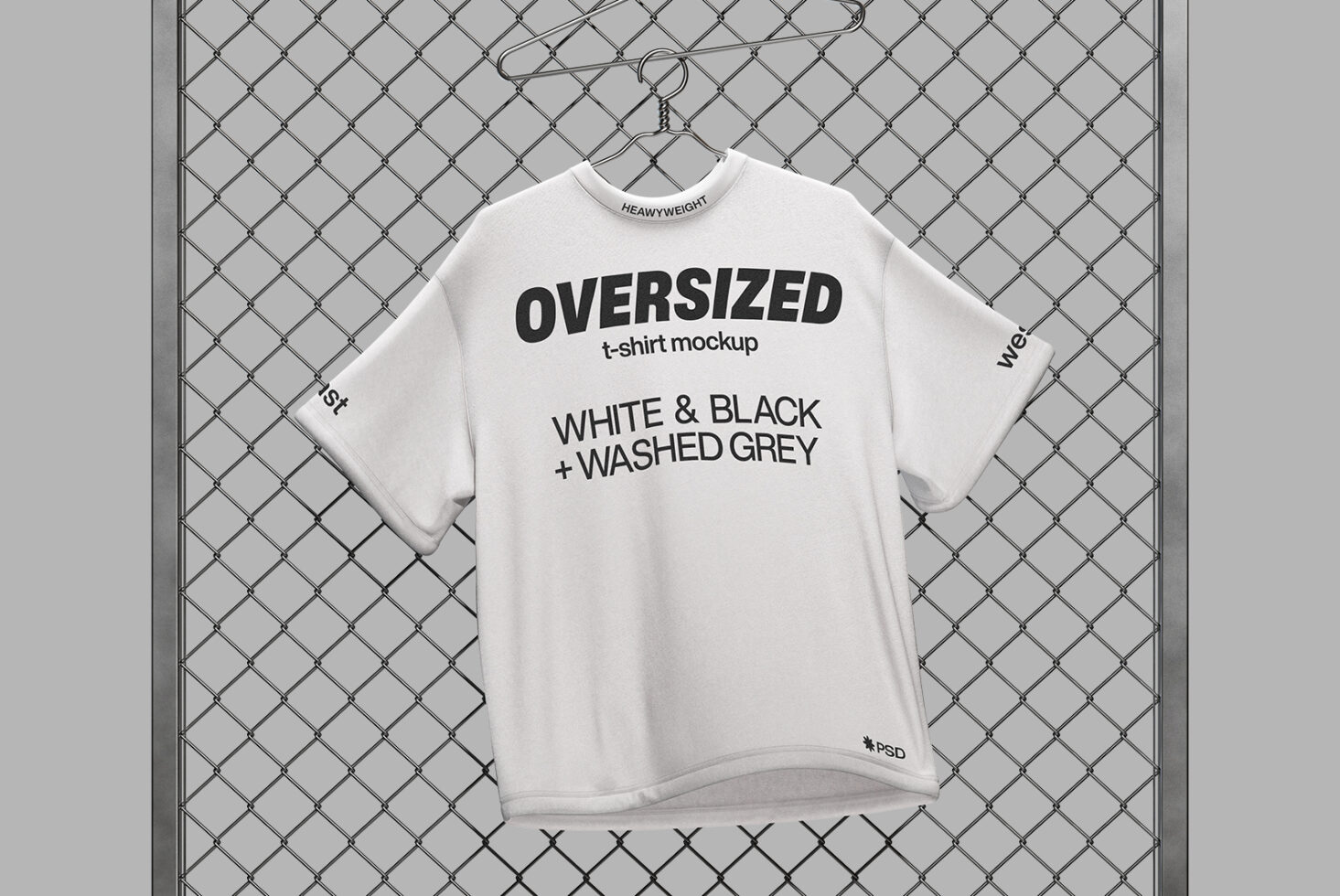 Cream oversized tee mockup on hanger against chain-link fence, front view