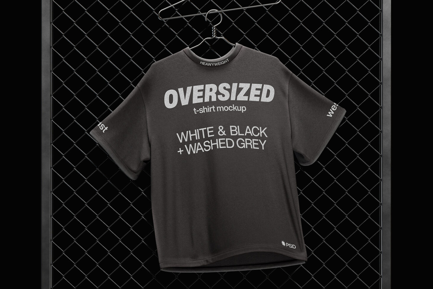 Charcoal oversized tee crewneck on hanger against chain-link fence, close-up