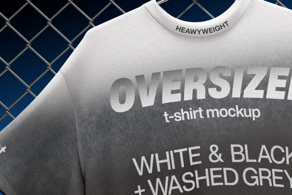 Close-up of heavyweight oversized tee showing embossed text on fabric against chain-link backdrop