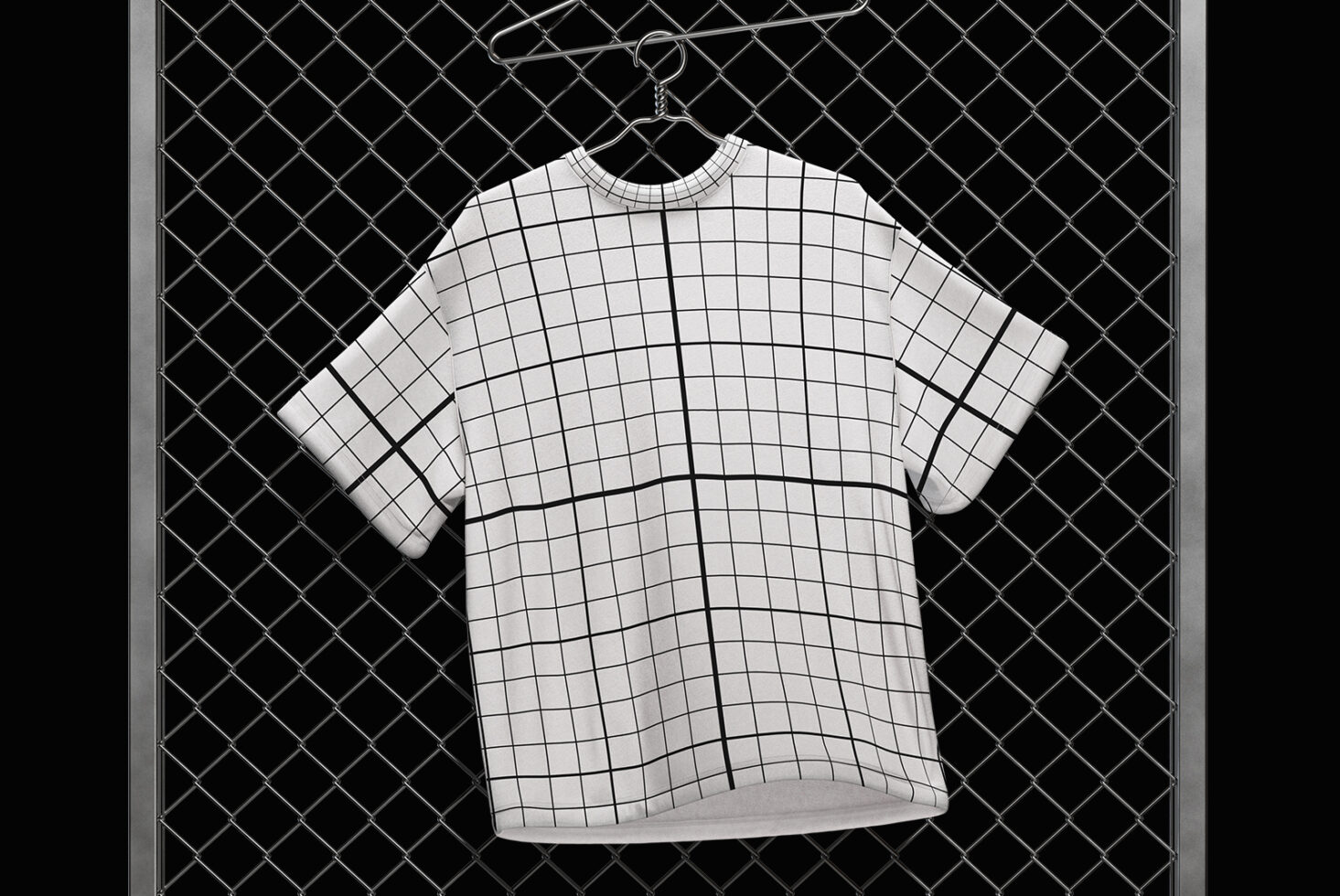 Grid pattern t-shirt mockup on hanger with chain against black chain-link background