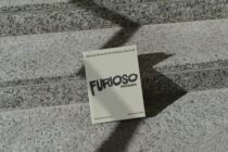 Cream colored card mockup with black Furioso lettering on concrete steps