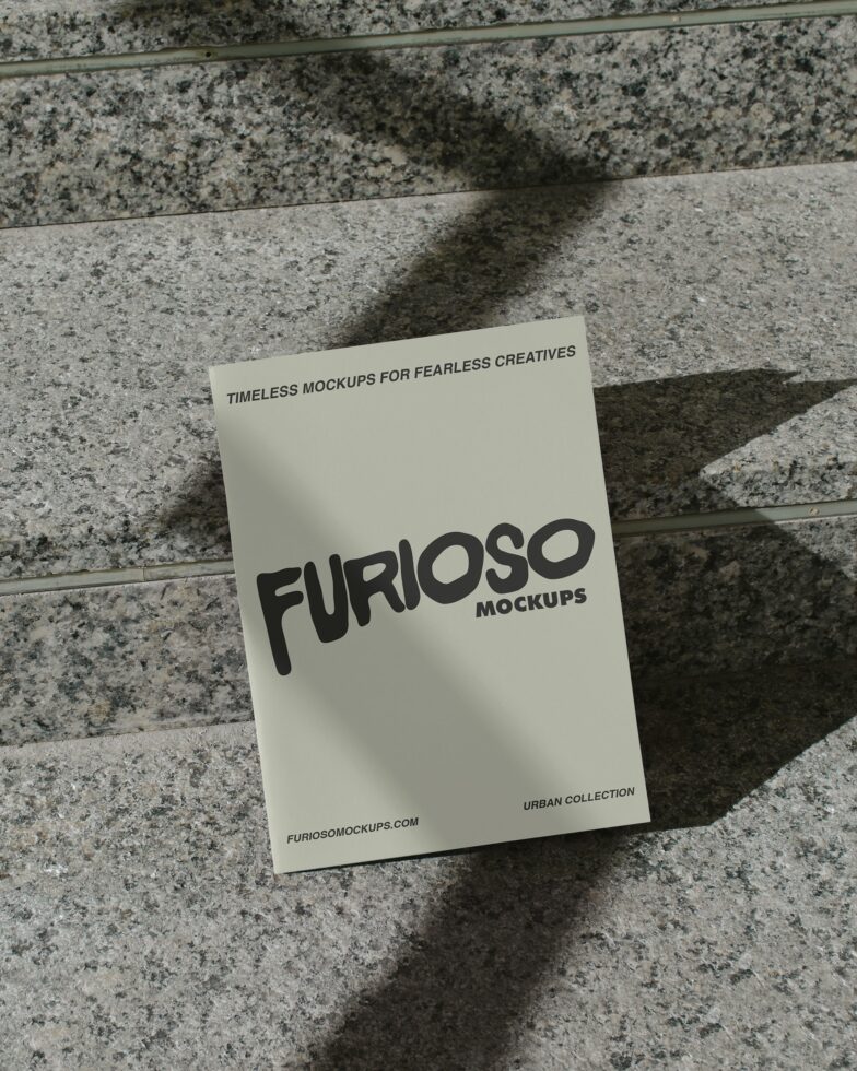 Cream card with black FURIOSO logo on textured concrete with sunlight
