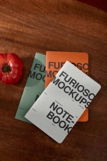 Three stacked notebook mockups on wood with fresh tomato, white orange cream covers with typography